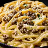 A bowl of pasta with meat and cheese.